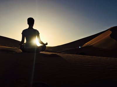 Die abendliche Sonne in der Wüste Sahara mit Yoga verabschieden