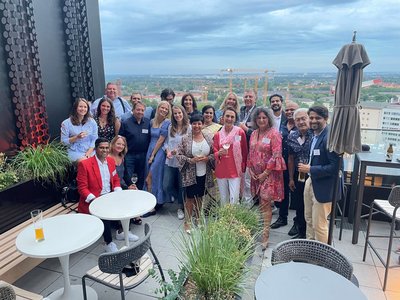 Das NEUE WEGE Team auf einer Terrasse mit Ausblick auf München