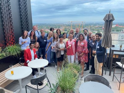 Das NEUE WEGE Team auf einer Terrasse mit Ausblick auf München