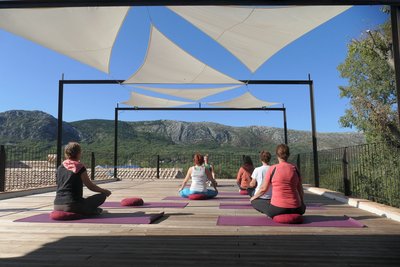 Üben Sie Yoga auf der Plattform mit Blick auf das Karstgebirge