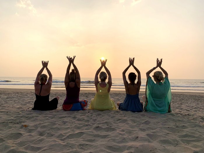 Yoga Gruppe am Strand bei Sonnenuntergang