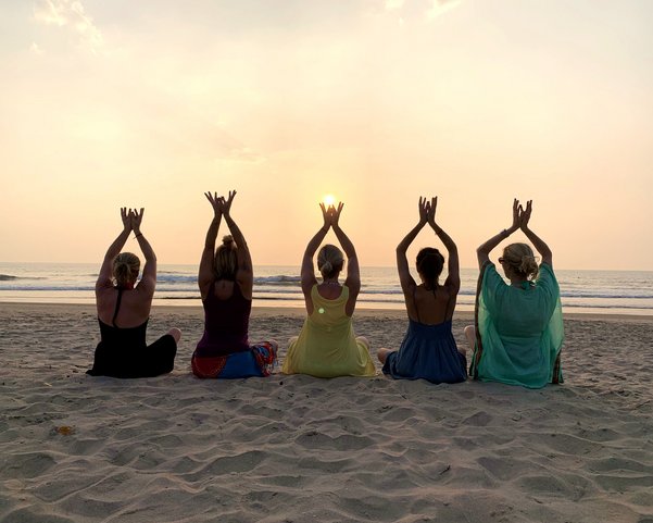 Yoga Gruppe am Strand bei Sonnenuntergang