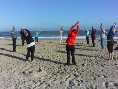 Entspannen Sie bei einer Yoga-Einheit in einer Gruppe am Strand